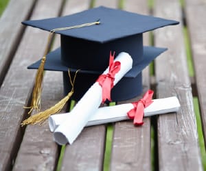 Two graduation caps and two diplomas